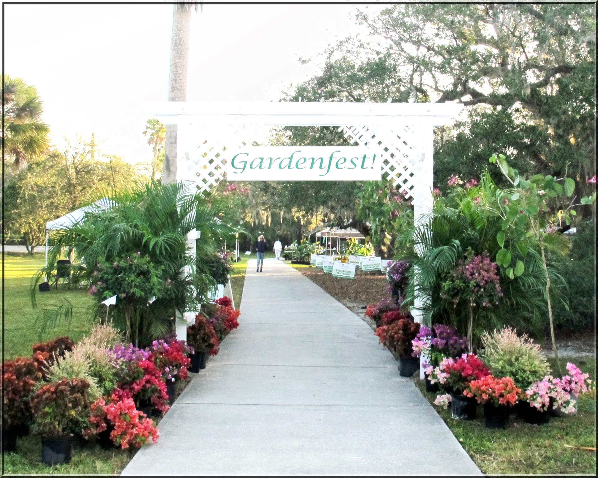 Sidewalk entrance to Gardenfest! with Gardenfest! sign and plants lined along the sidewalk